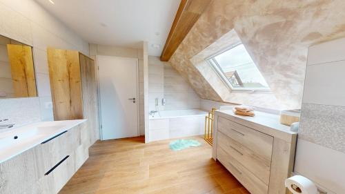 a bathroom with a sink and a tub and a window at Mon petit chez soi en Alsace in Rountzenheim