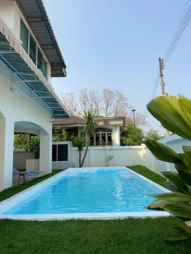 a swimming pool in the yard of a house at ChiangMai RedDoor Pool Villa in Chiang Mai