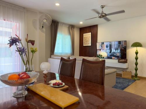 a living room with a dining table and a couch at ChiangMai RedDoor Pool Villa in Chiang Mai