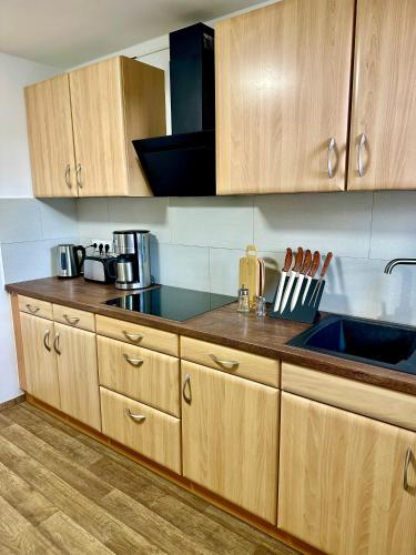 a kitchen with wooden cabinets and a counter top at Ferienwohnung Gerdi in Hoyerswerda
