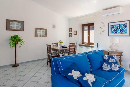 a living room with a blue couch and a table at Mare Amore Fantasia in Gaeta