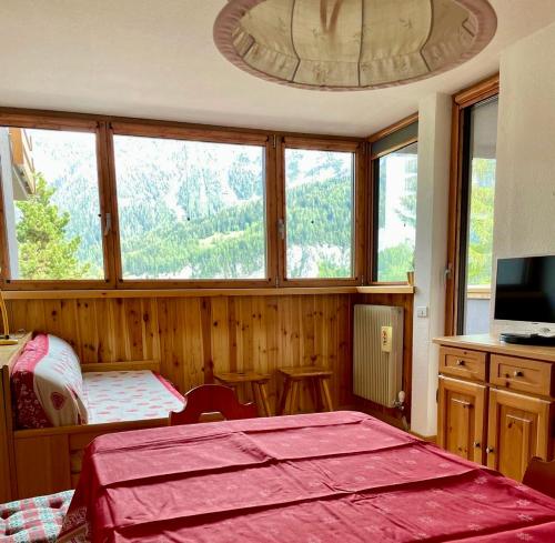 a bedroom with a bed and a large window at Appartamento - Residence I Larici in Folgarida