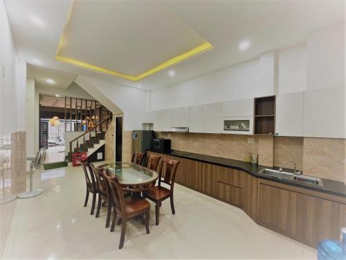 a kitchen with a table and chairs and a staircase at Ha Linh Home-My Khe Beach-Kitchen-High speed Wifi in Da Nang