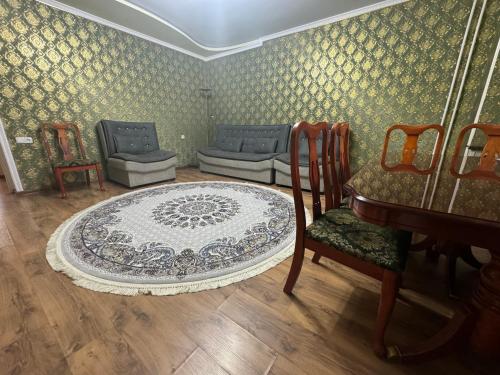 a room with chairs and a table and a rug at Large Appartment & Central Place in Tashkent