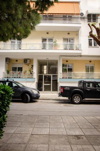 a building with cars parked in front of it at M & E Guesthouse in Volos