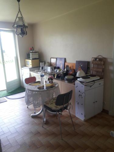 a kitchen with a table and a small table with chairs at Chambre de la baronne de Rochegrosse in Saint-Maurice-en-Gourgois