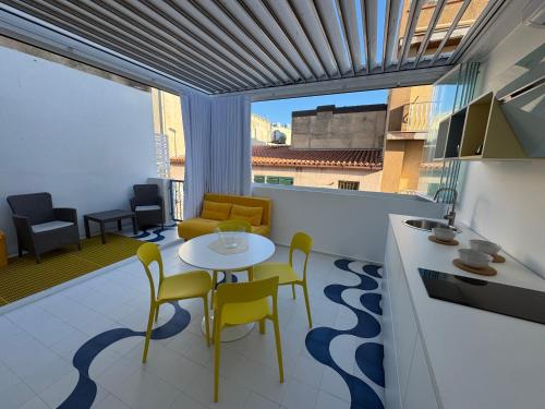 sala de estar con mesa y sillas en el balcón en Soleonde, en Marina di Ragusa