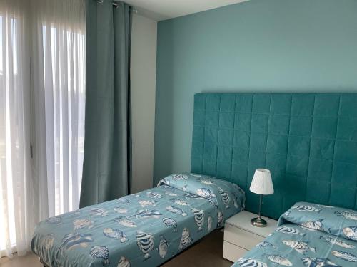 a bedroom with two beds and a green headboard at Polinesia 11 in Lido delle Nazioni