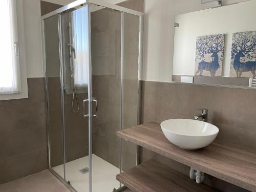 a bathroom with a glass shower and a sink at Polinesia 11 in Lido delle Nazioni