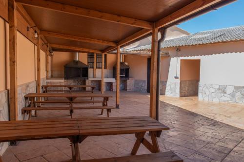 a patio with wooden benches and an outdoor kitchen at Apartamentos La Jasa in Arguedas