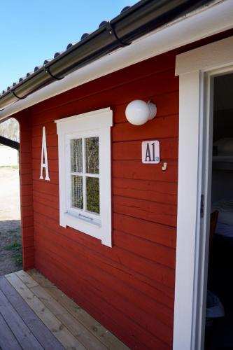 a red house with a window and aaa sign on it at Vimmerby Camping in Vimmerby