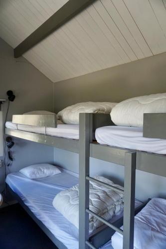 a room with three bunk beds in a room at Vimmerby Camping in Vimmerby