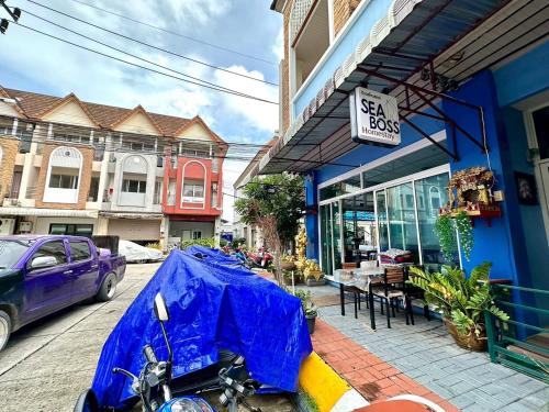 a motorcycle parked in front of a blue building at Sea Boss Homestay in Kata Beach