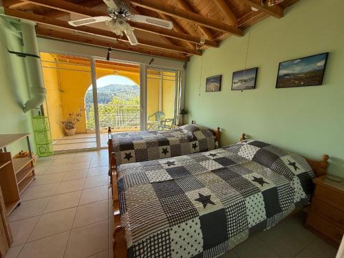 a bedroom with two beds and a window with a view at Villa Mike's House in Apolpaina