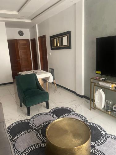 a living room with a green chair and a television at Magnifique in Dakan