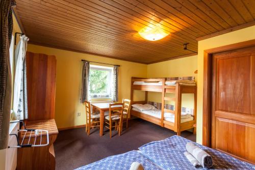 sypialnia z łóżkiem, biurkiem i stołem w obiekcie Haus Wildbach - Baranek Resorts w mieście Leogang
