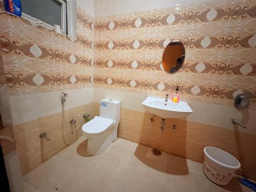 un bagno con un water e un lavandino di Atulyam Stays Sushant Golf City a Lucknow
