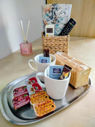 a tray with cups of tea and cookies on a table at Hotel Europa - Family and Senior Friendly in Kavala