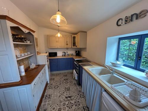 une cuisine avec des armoires bleues et un évier dans l'établissement Petit Parfait 3 bedroomed house, à Buais