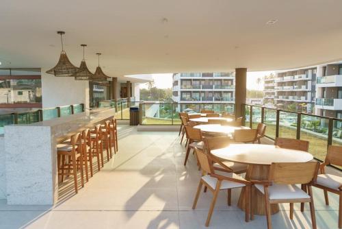 restauracja ze stołami i krzesłami na balkonie w obiekcie Flat at Makia in Muro Alto Porto de Galinhas w mieście Porto de Galinhas