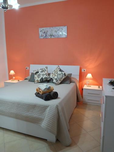 a bedroom with a white bed with an orange wall at Da Cate in Monterosso al Mare