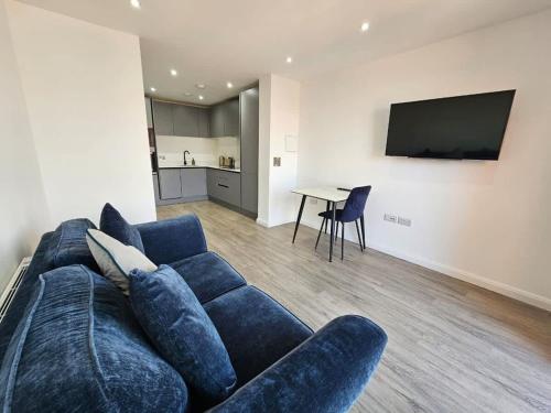 a living room with a blue couch and a table at 2 Bedroom Flat in Belfast in Belfast