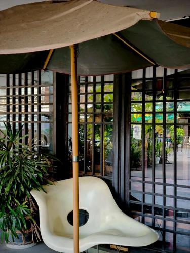 a chair under an umbrella in front of a building at Centric Place Hotel in Bangkok