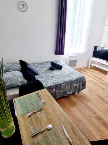 une chambre avec un lit et une table en bois dans l'établissement Studio 2 Cosy en centre-ville - Puy duFou, aux Herbiers