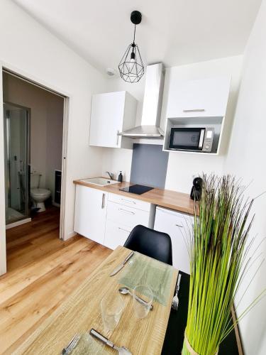 une petite cuisine avec une table en bois et une salle à manger dans l'établissement Studio 2 Cosy en centre-ville - Puy duFou, aux Herbiers