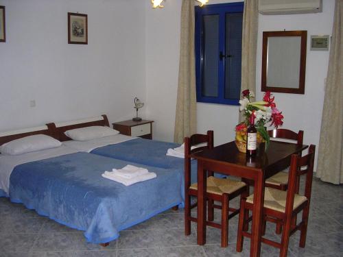 Agia FotiaにあるStefanos Apartmentsのベッドルーム1室(ベッド1台、テーブル、テーブル、椅子付)
