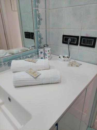 a white bathroom counter with towels and a mirror at Blue's House in Atrani