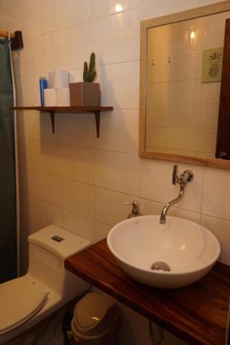 a bathroom with a sink and a toilet and a mirror at Sapa Inka in Montañita