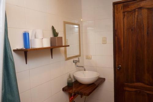 a bathroom with a white sink and a mirror at Sapa Inka in Montañita