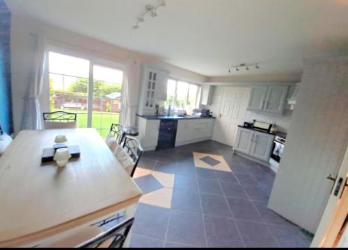 a large kitchen with white cabinets and a table at Newry Premium B&B in Newry