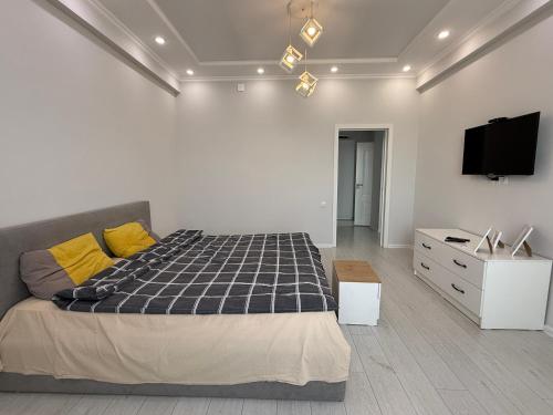 a bedroom with a bed and a tv on a wall at It's located center of Bishkek in Bishkek