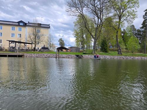 a body of water with a building in the background at Norrqvarn Hotel & Resort by Vänerport in Lyrestad