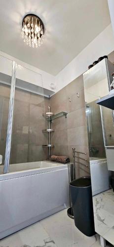 La salle de bains est pourvue d'une grande baignoire et d'un lavabo. dans l'établissement Top Floor with Sea View, Clim and Veranda, à Nice