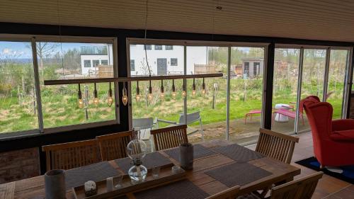 a dining room with a table and chairs and windows at Farhults Garden in Farhult