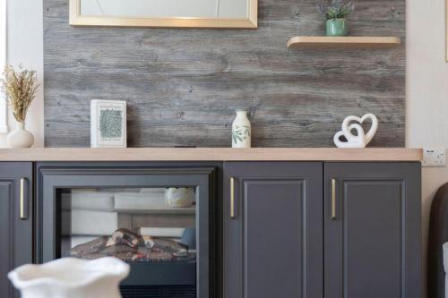 a fireplace in a living room with a wooden wall at Vacant Nests Seton Sands The Wentworth Wifi in Port Seton