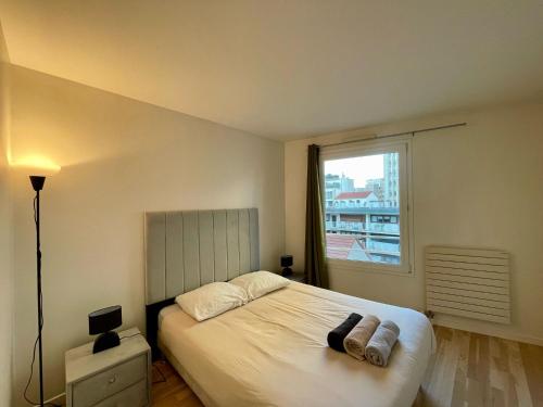 une chambre avec un grand lit avec une fenêtre dans l'établissement Appartement Montparnasse Castagnary Paris, à Paris