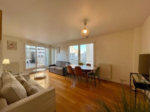 un salon avec un canapé et une table dans l'établissement Appartement Montparnasse Castagnary Paris, à Paris