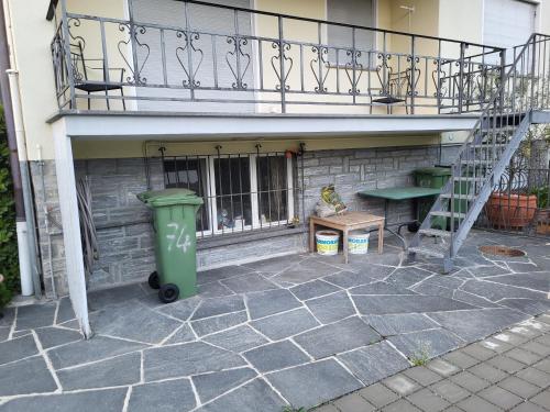 a green trash can sitting under a balcony at New "Casa Maria" in Ascona