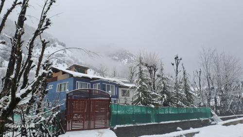 a blue train in the snow with a fence at Al-Ayaan Guest House in Pahalgām