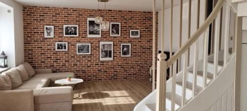 un salon avec un canapé et un mur de briques dans l'établissement Bretagne maison proche de la mer de 4 à 8 personnes, à Plouégat-Guérand