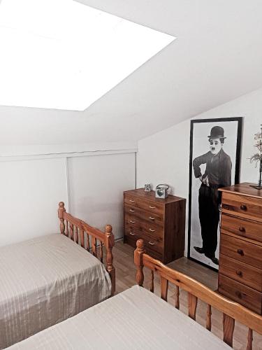 une chambre avec une commode et une photo d'un homme dans l'établissement A PIEDS NUS JUSQU'A LA MER, à Six-Fours-les-Plages