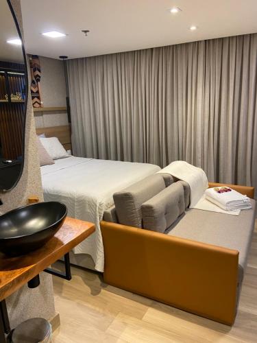 a room with a bed and a couch and a table at Frente Mar de Cabo Branco - Setai Edition in João Pessoa