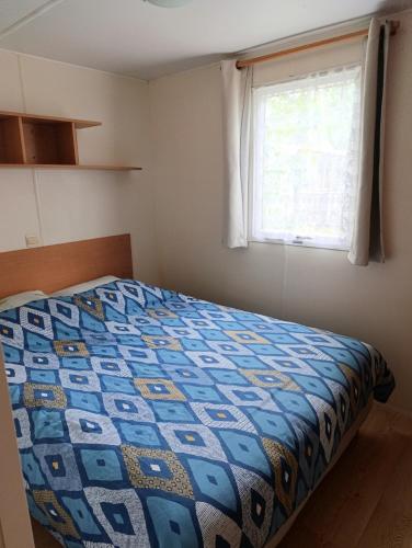 une chambre avec un lit avec une couette dessus dans l'établissement Les sables d'or de Malo et Elsa, au Grau-dʼAgde