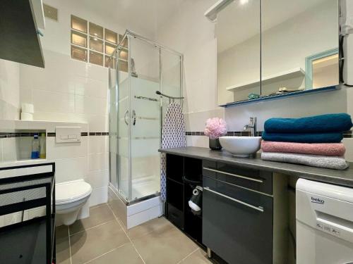 Un baño con ducha, lavabo e inodoro. en Studio Auteuil Suchet Paris, en París