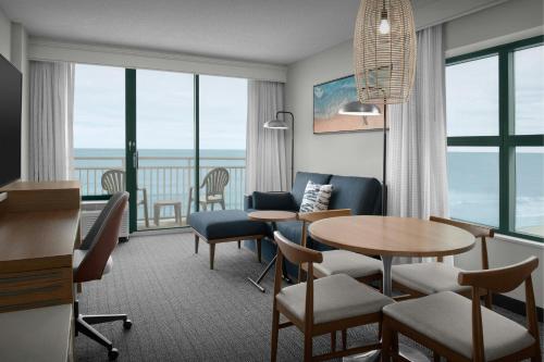 a hotel room with a table and chairs at Courtyard Virginia Beach Oceanfront/South in Virginia Beach