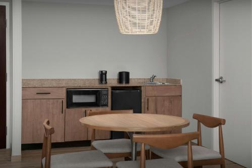 a kitchen with a table and some chairs and a counter at Courtyard Virginia Beach Oceanfront/South in Virginia Beach